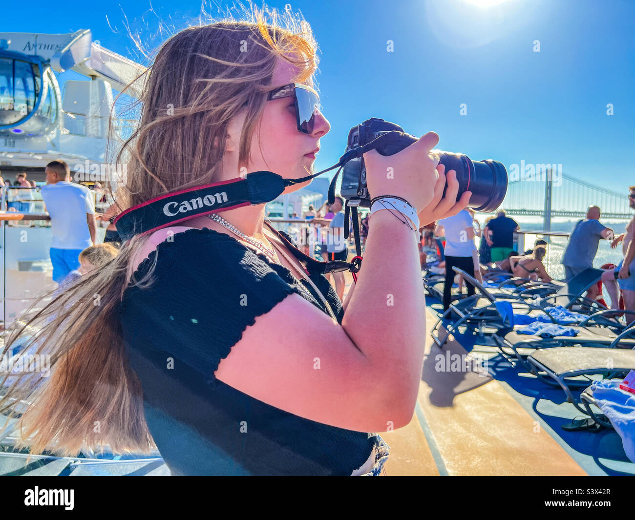 Young woman taking photos with canon camera while on a cruise in Lisbon Portugal - Smartphone Captured Stock Image