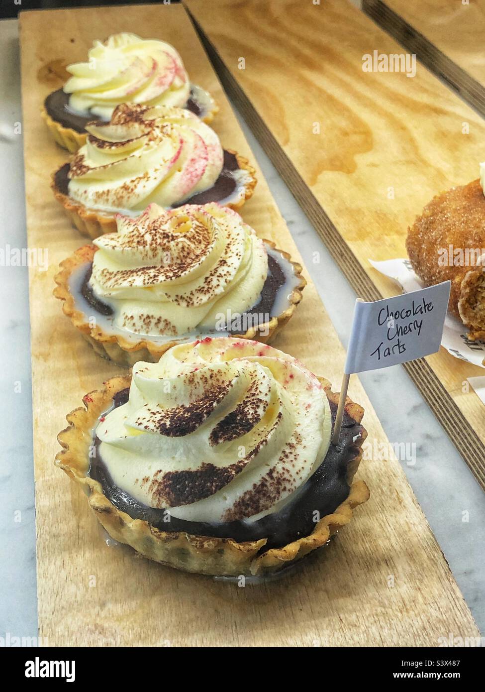 Cake Chocolate Cherry Tarts in bakery window - Smartphone Captured Stock Image