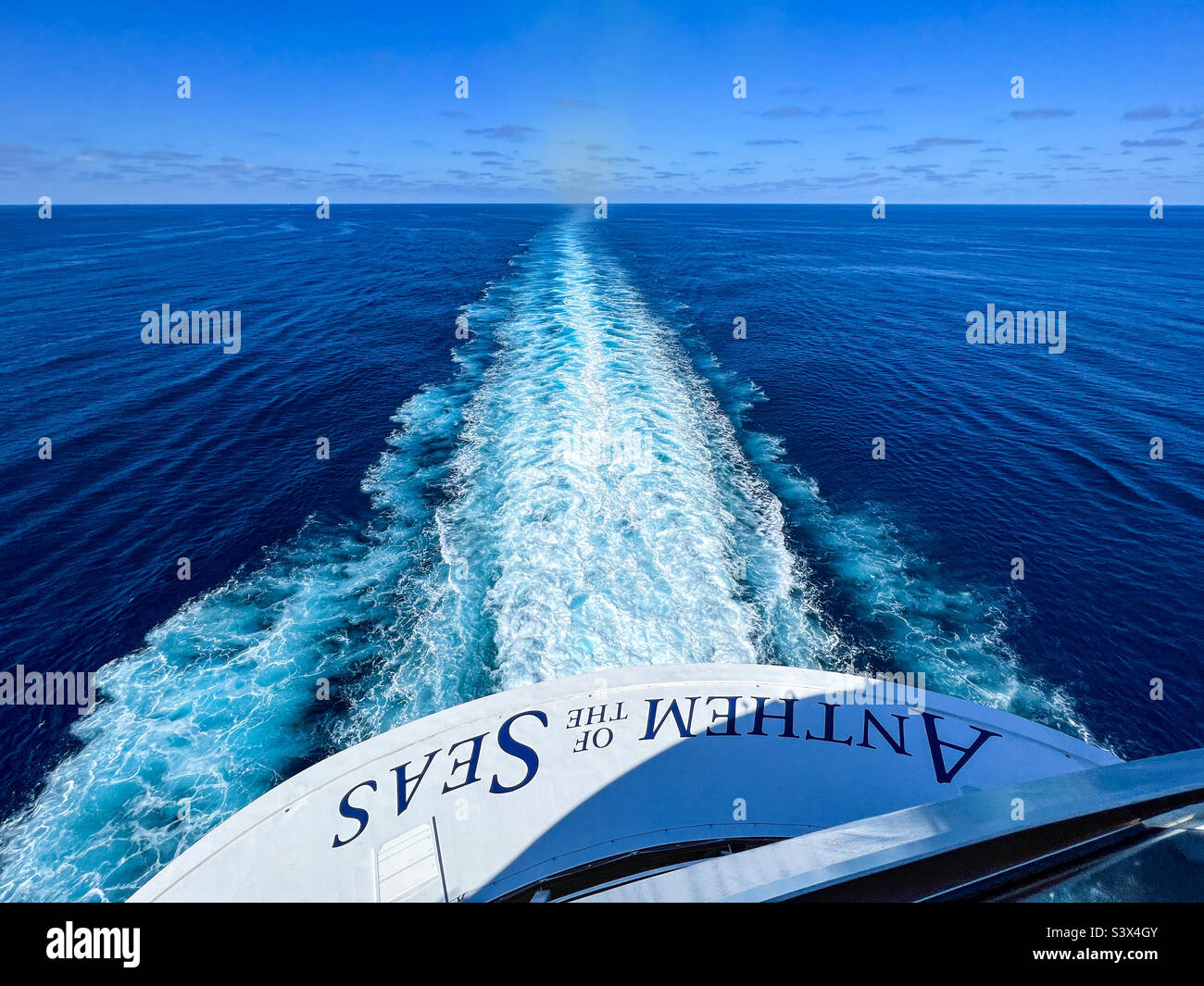 Cruise ship wake stretching from the stern to the blue sky horizon across the still North Atlantic Ocean - Smartphone Captured Stock Image