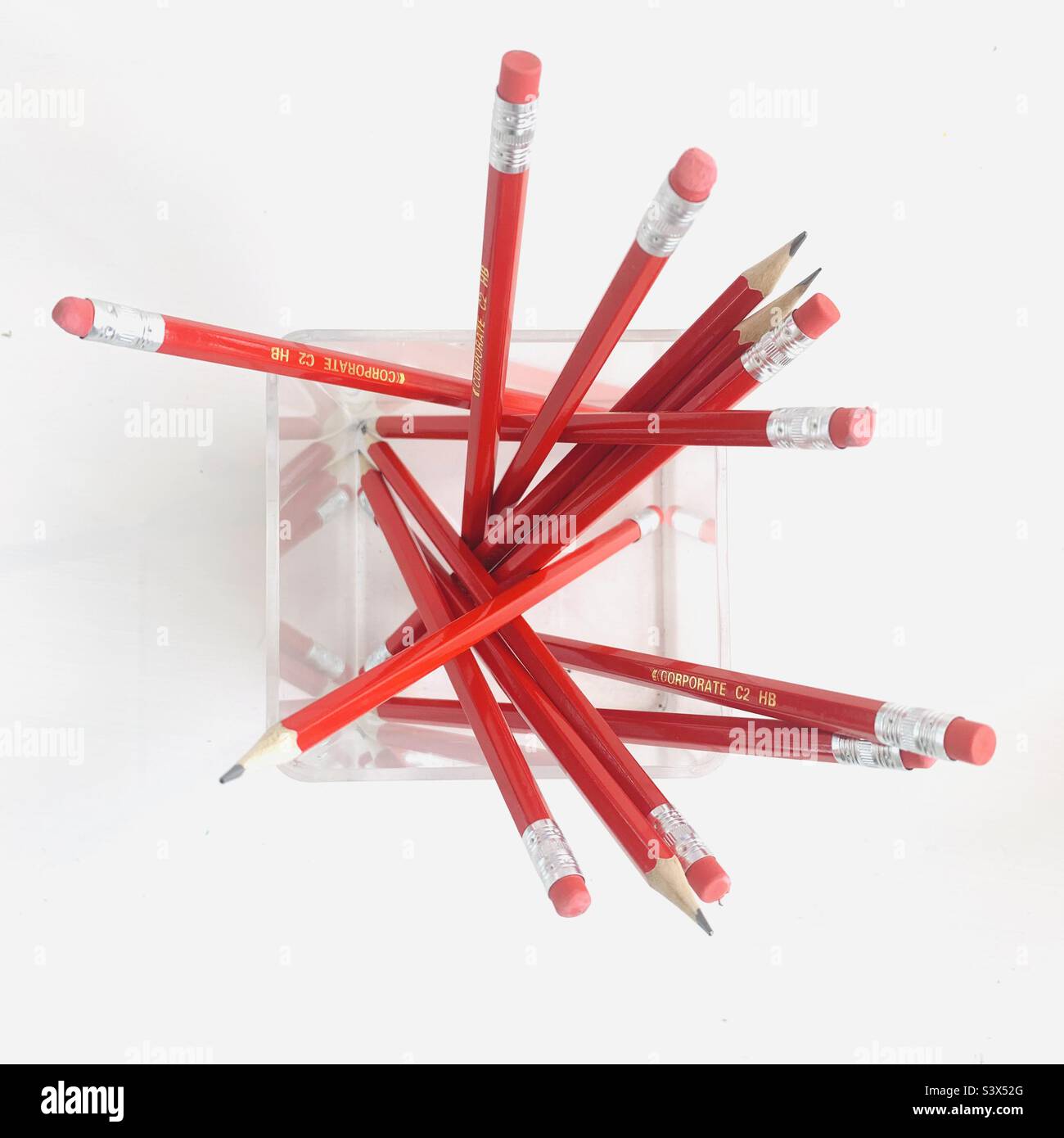 Red pencils in a clear container arranged graphically on a white desk table top - Smartphone Captured Stock Image