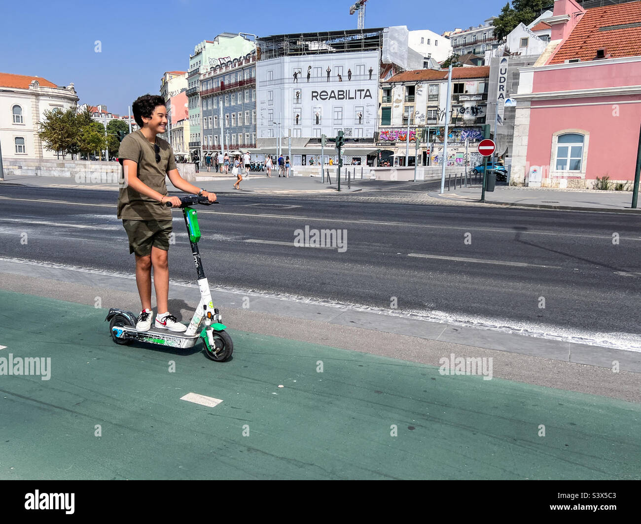 Young man riding his electric scooter in Lisbon Portugal - Smartphone Captured Stock Image
