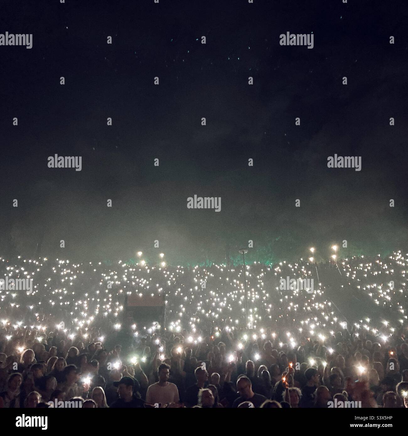 Crowd at a pop concert Holding up their mobile phone flashlights Stock Photo