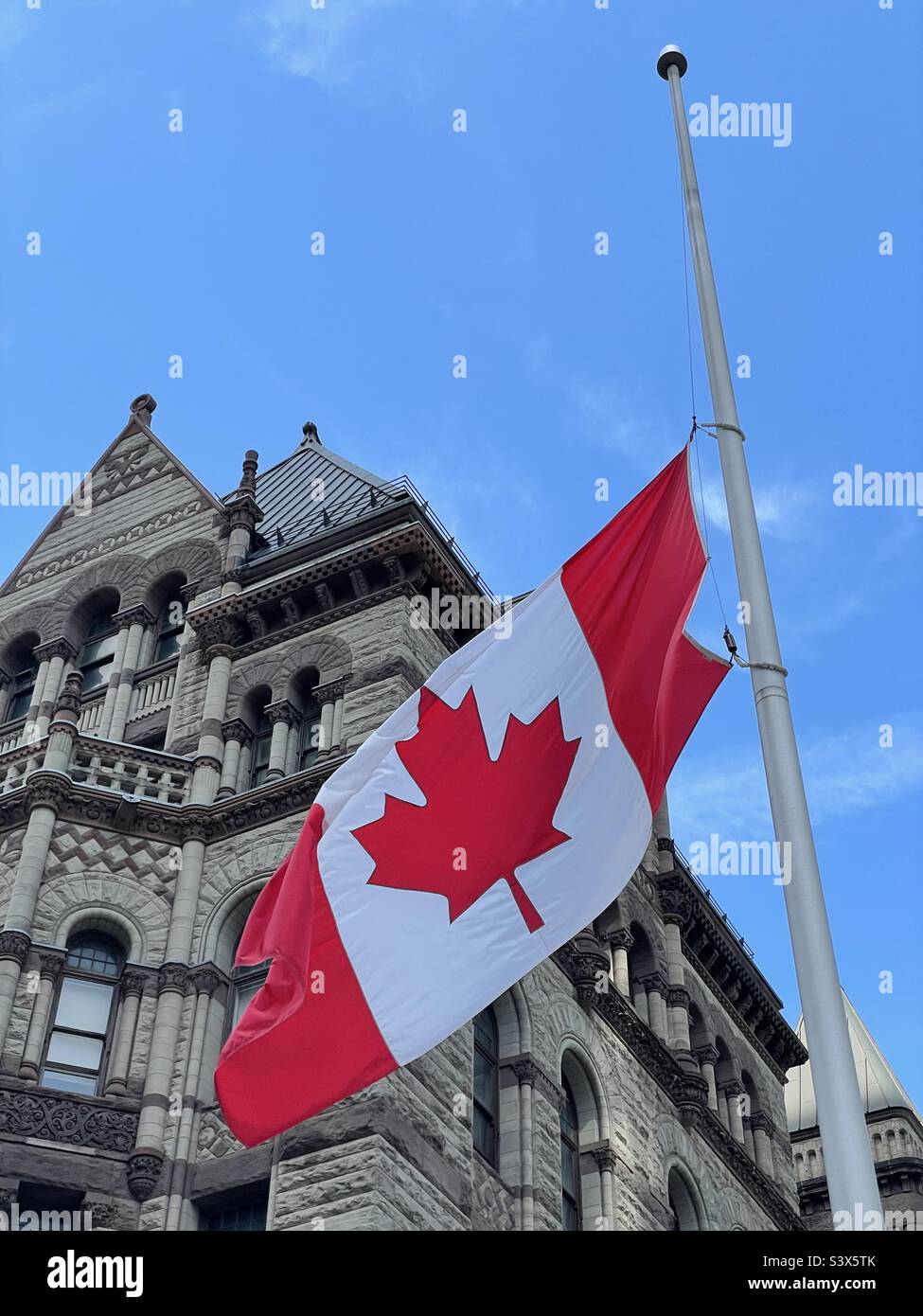 Canadian flag flying at half-mast at Toronto old city hall. Toronto, Ontario. Stock Photo