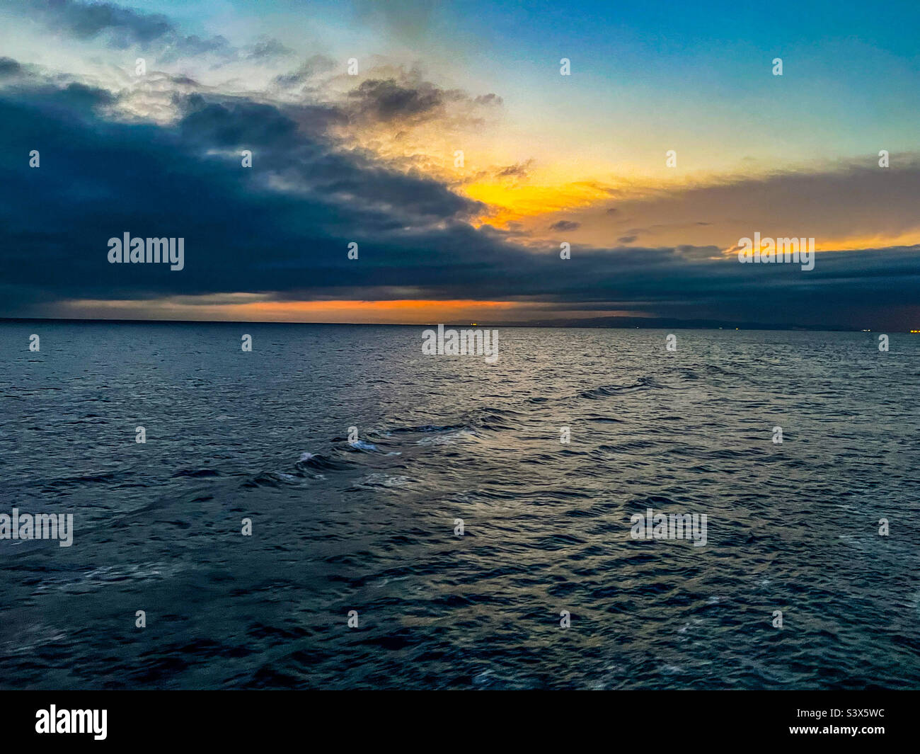 Sun setting over the Balearic sea in the Mediterranean with Barcelona in view Stock Photo