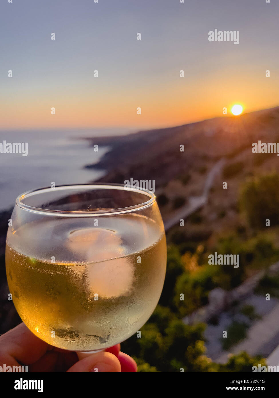 Drinking a glass of wine during sunset on the island of Crete - Smartphone Captured Stock Image