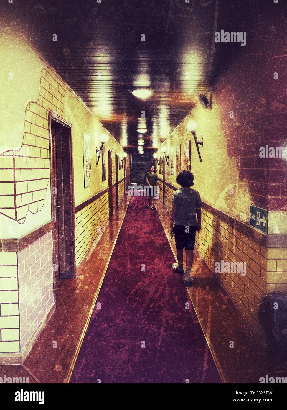 Eleven years old brown hair boy walking in an hotel corridor - Smartphone Captured Stock Image