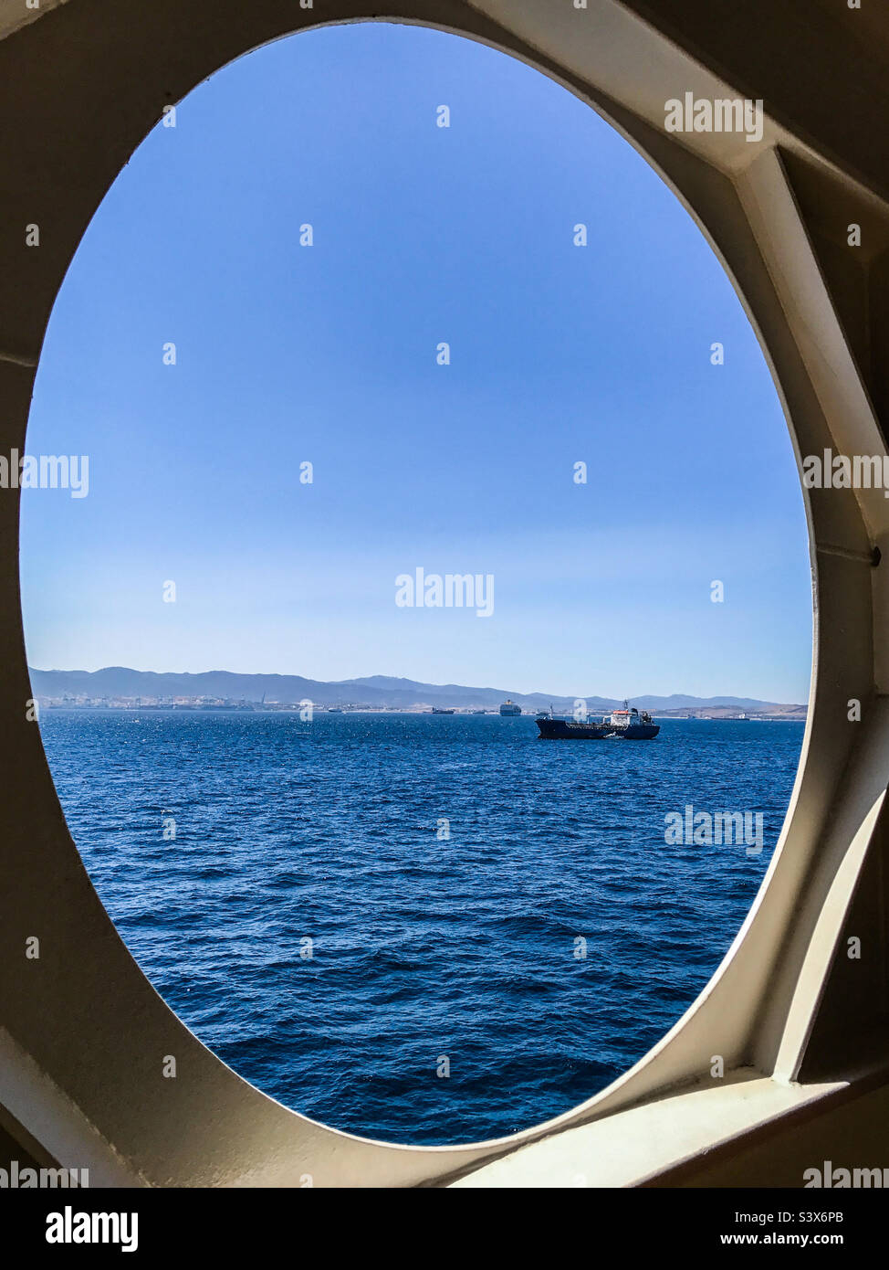 Open ship port hole looking onto Strait of Gibraltar Stock Photo