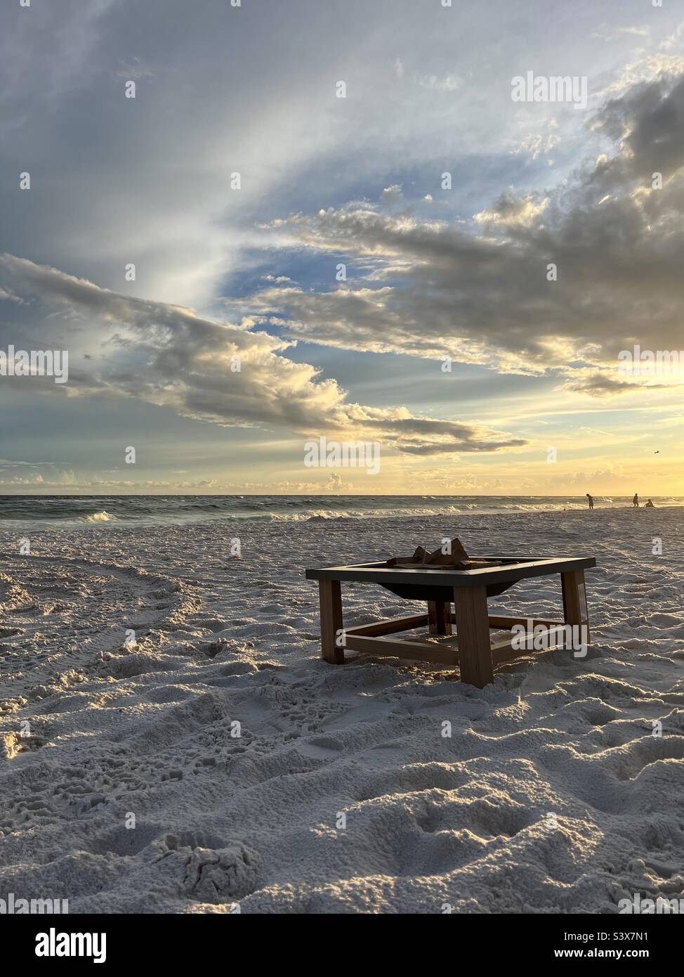 Fire pit on beach sand with sunset sky background - Smartphone Captured Stock Image
