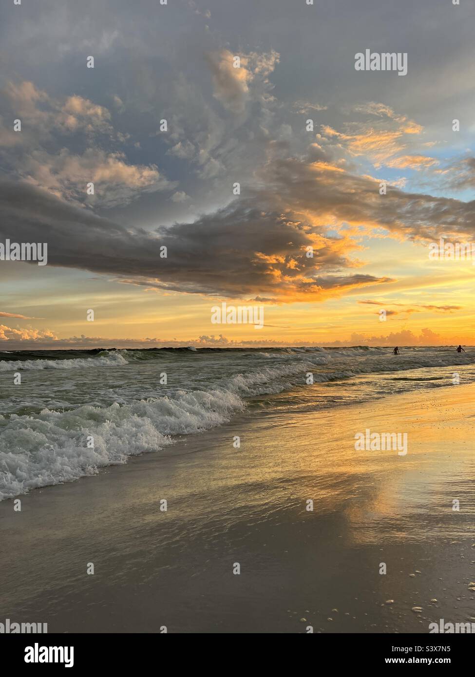 Golden Florida beach sunset with reflections on the sand Stock Photo