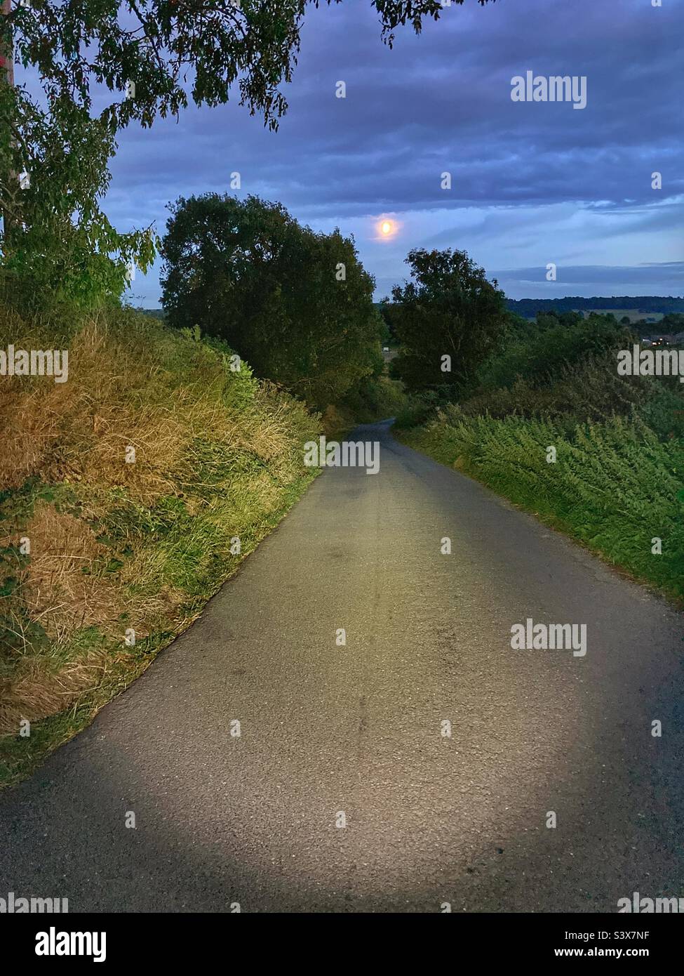 Riding down Castley Lane in Yorkshire at night towards the moon. - Smartphone Captured Stock Image