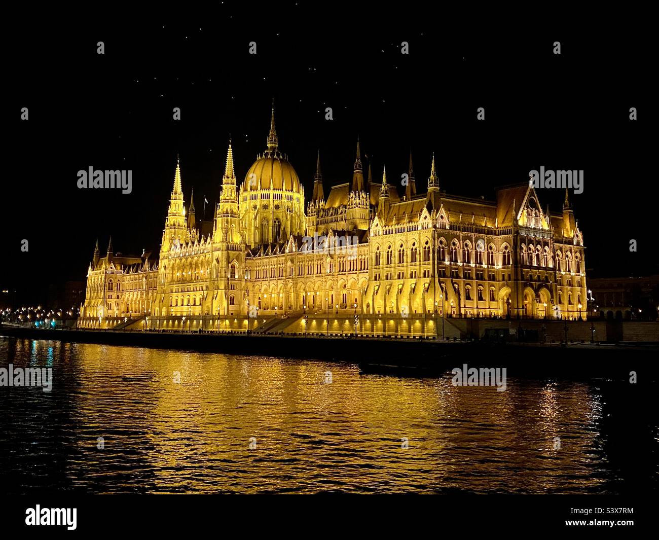 The Parliament building in Budapest in Hungary illuminated at night viewed from the river Danube Stock Photo