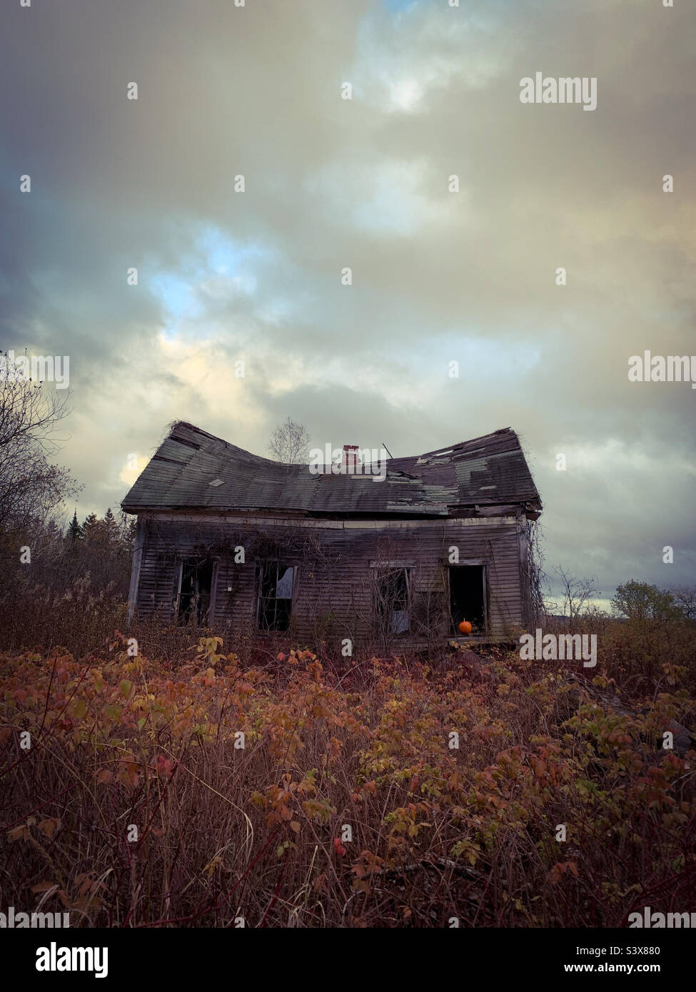 A haunted house with a pumpkin in the window. - Smartphone Captured Stock Image