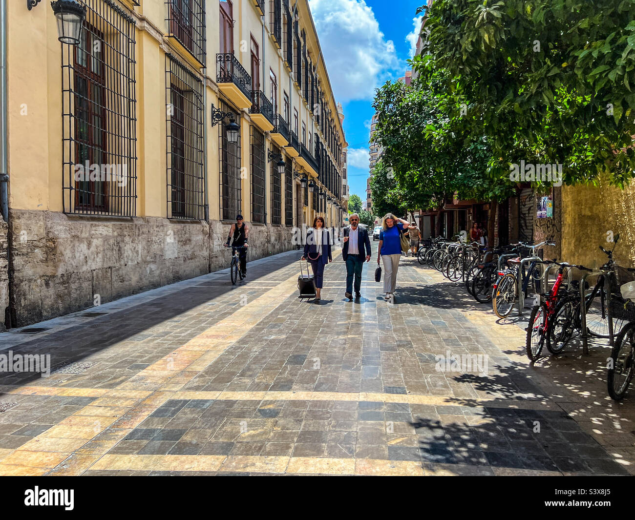 Business leaders walking down street discussing business in Valencia in Spain - Smartphone Captured Stock Image