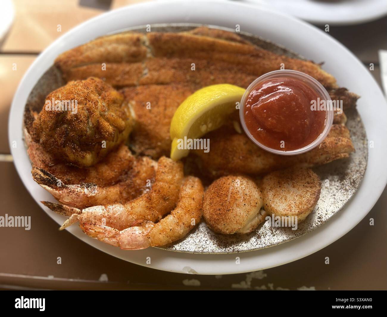 Seafood platter with scallops, shrimp, blackened fish, crabcake , lemon Stock Photo Alamy