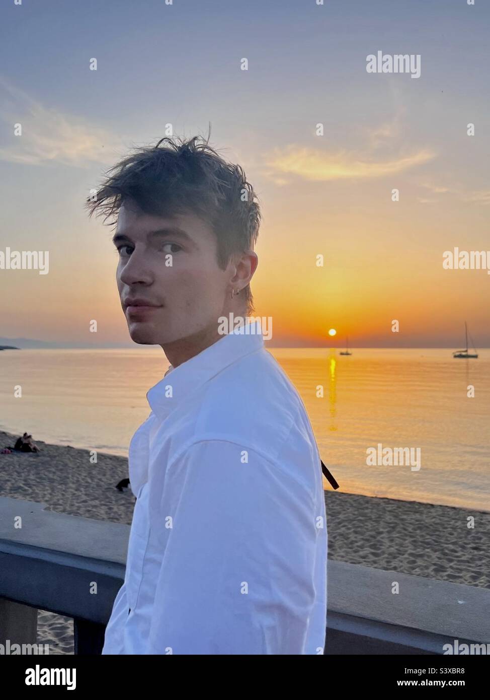 Portrait of a handsome young man enjoying a sunset in Cefalu, Sicily, Italy. - Smartphone Captured Stock Image