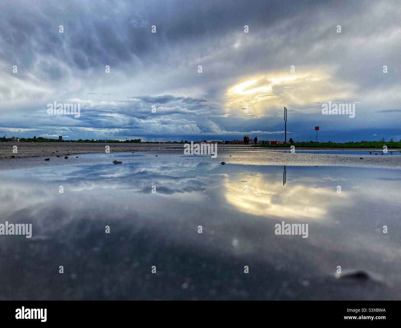 A dramatic Sky reflected in a puddle on Tempelhofer Feld, Berlin, Germany Stock Photo