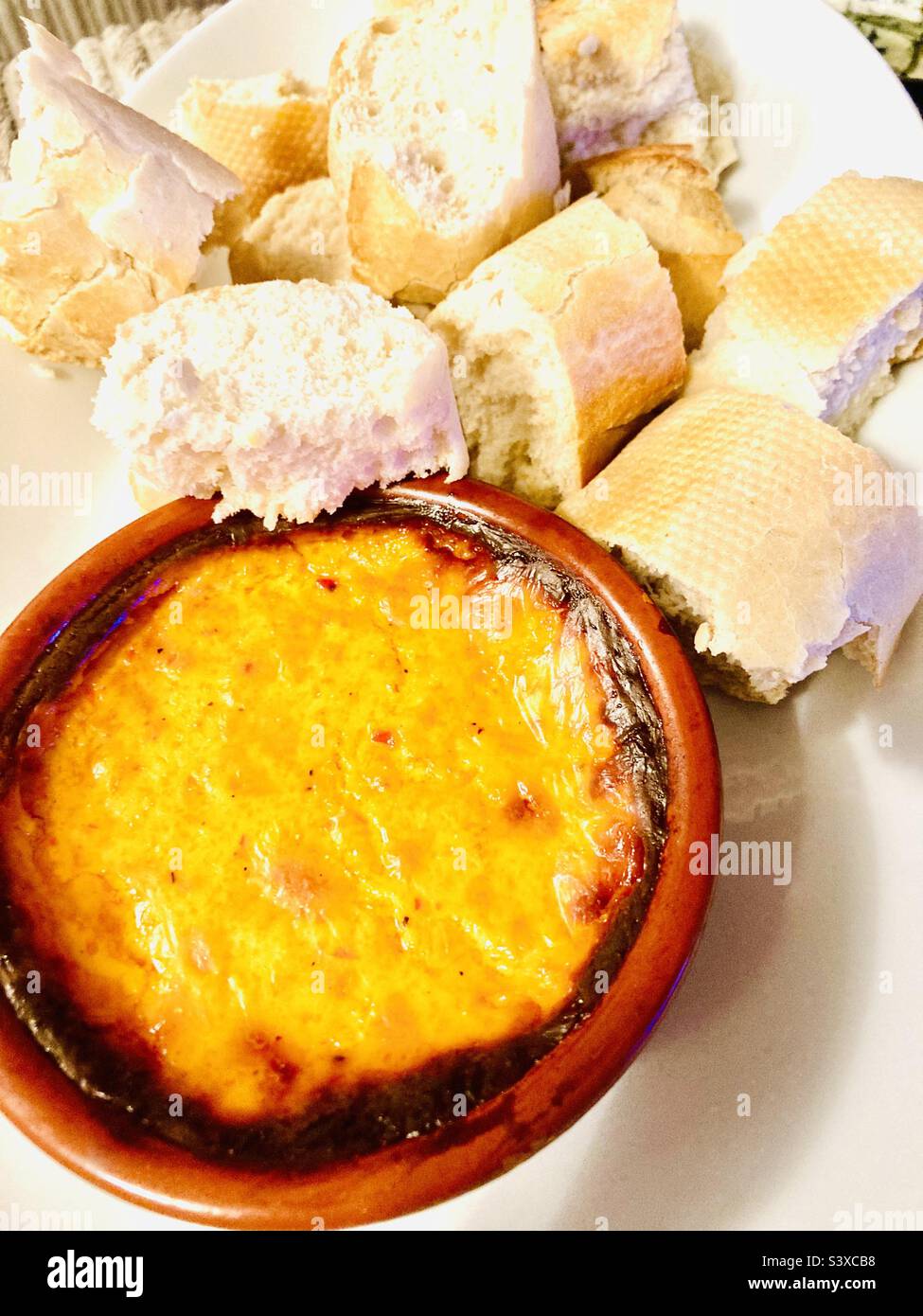 Strong cheese dipping sauce with fresh crusty bread Stock Photo