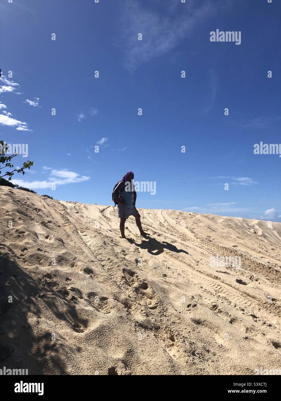 A man standing on the hill of a sand dune. Stock Photo