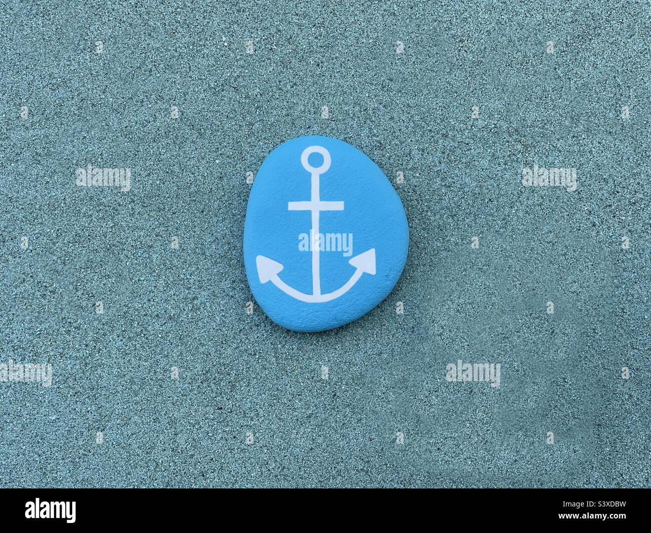 Stone anchor design over green sand - Smartphone Captured Stock Image