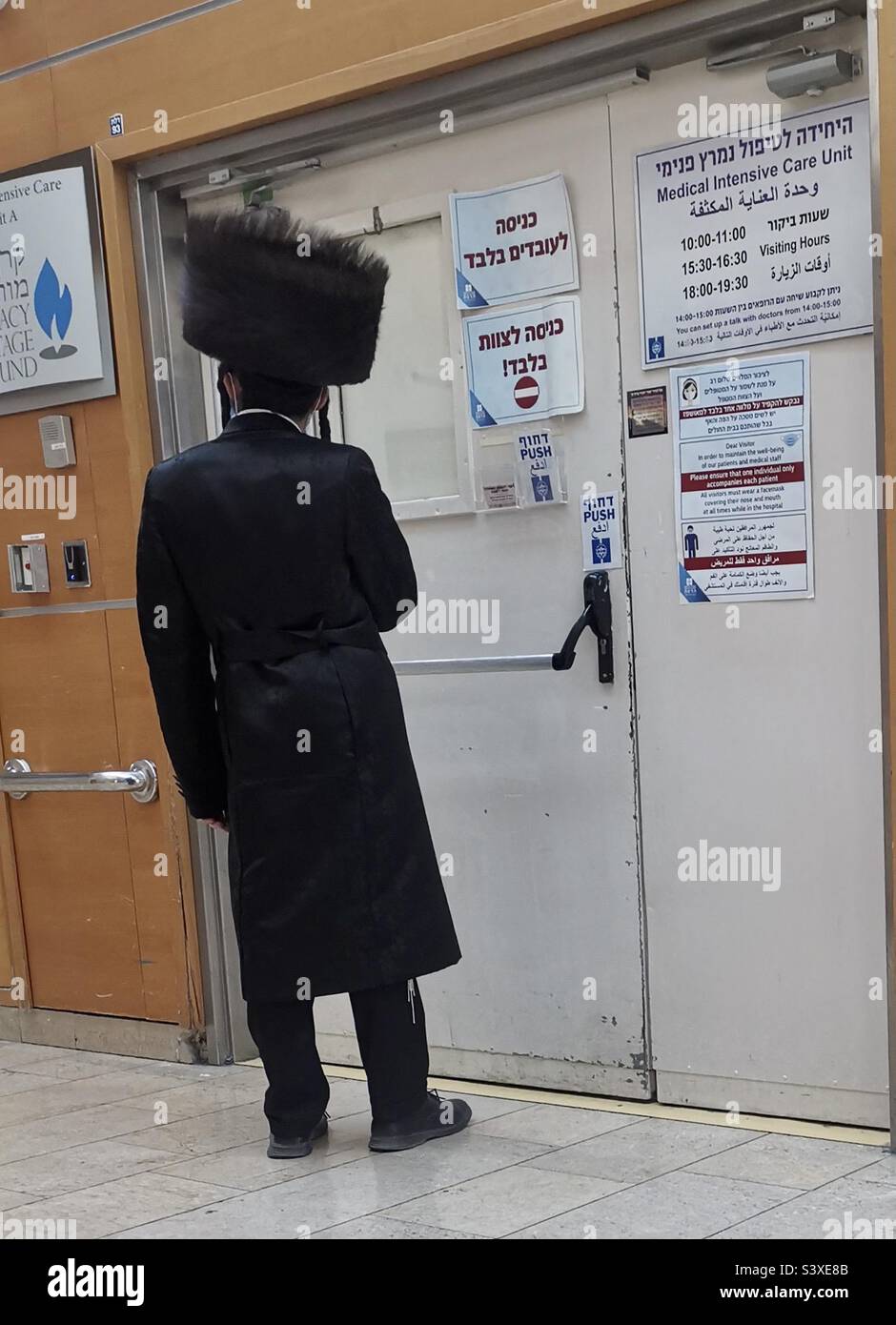 A Hasidic man wearing a traditional Spodik fur hat waiting at the
