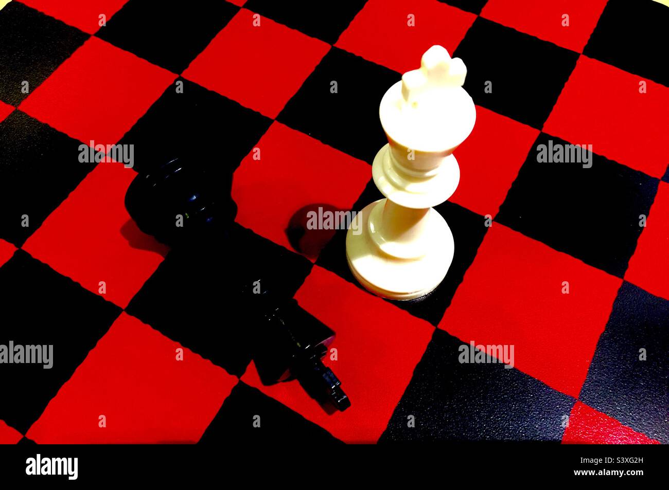 A king has fallen. Long live the King! Red and black chessboard. Metaphor for life. Up and down. Black King Down. - Smartphone Captured Stock Image