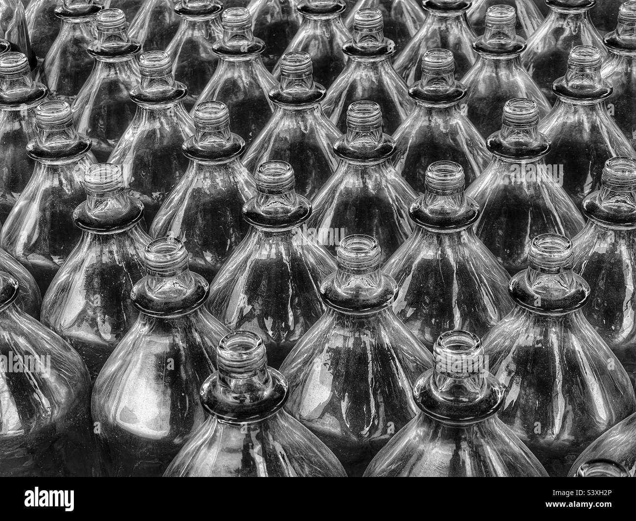 Clear glass bottles lined up for ring toss game at a carnival - Smartphone Captured Stock Image
