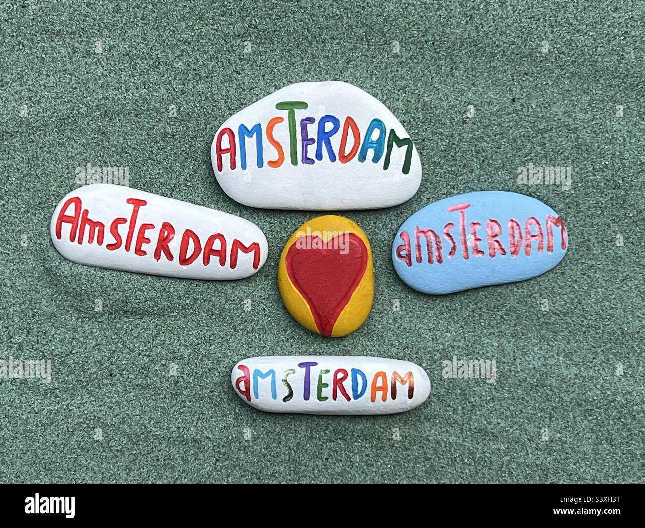 Stones handmade souvenirs over green sand - Smartphone Captured Stock Image