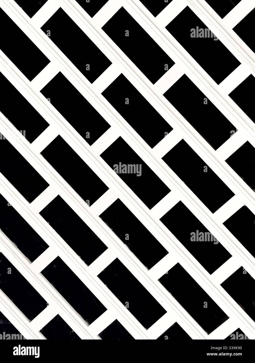 Pattern on a metal security grill over the entrance to a shop. No people. - Smartphone Captured Stock Image