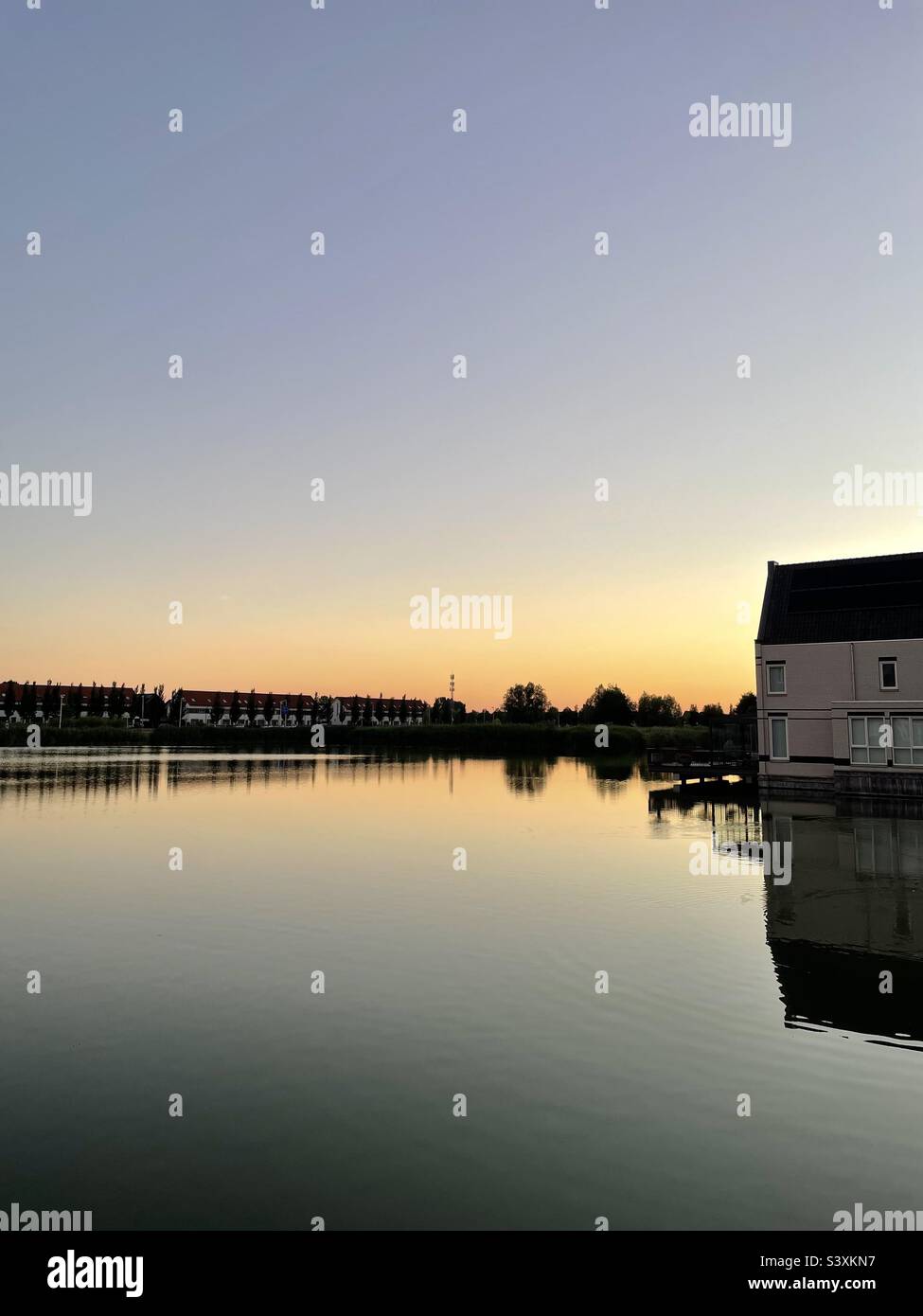 Sunset by the lake with an orange sky in the background - Smartphone Captured Stock Image