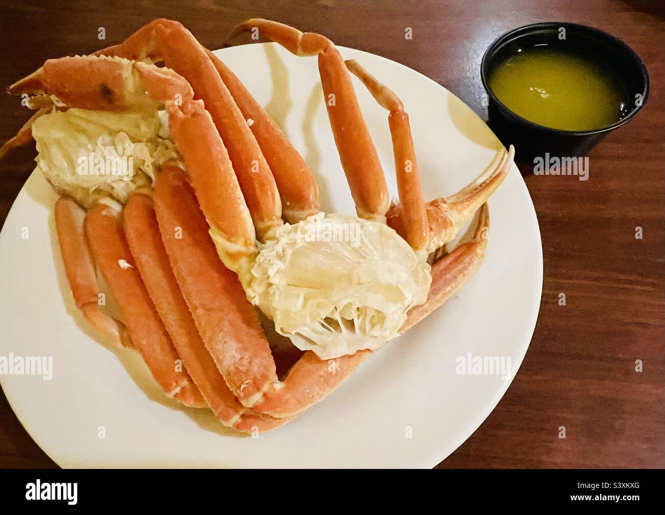 Plate of crab legs with side of drawn butter Stock Photo Alamy