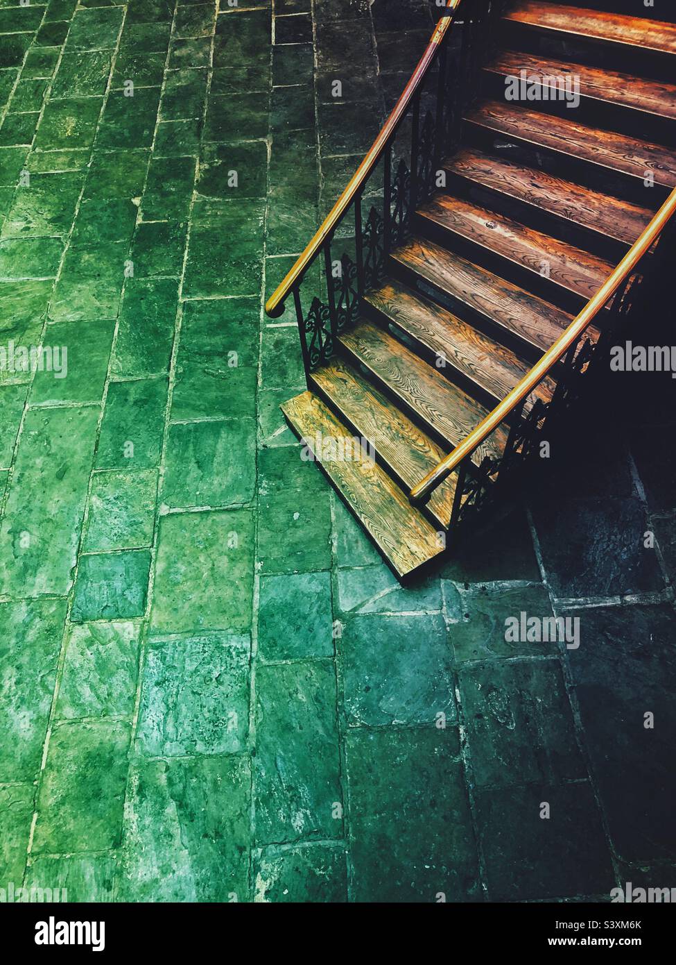 High angle view of an old wooden staircase winding downwards into a evil lair or dark basement with green light and copy space - Smartphone Captured Stock Image