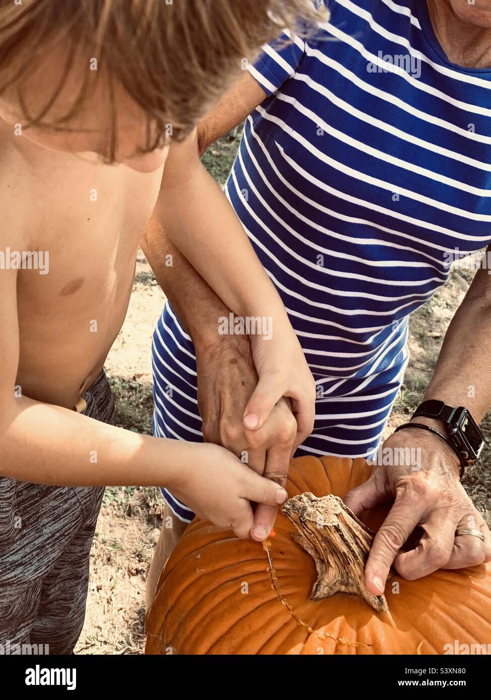 Older woman and child carving pumpkin together Stock Photo