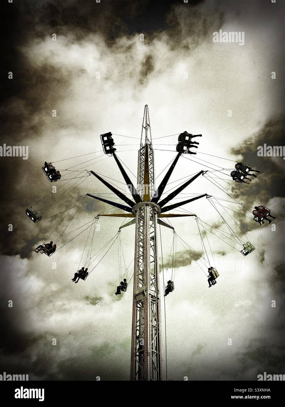 Fairground attraction at the Rood Fair, Whitesands, Dumfries town centre, Scotland.  Looking up at the swings whirling round, moody look. - Smartphone Captured Stock Image