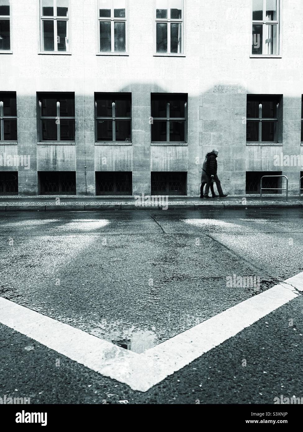 A Street scene of a couple walking in front of a building in Berlin Mitte, Germany - Smartphone Captured Stock Image