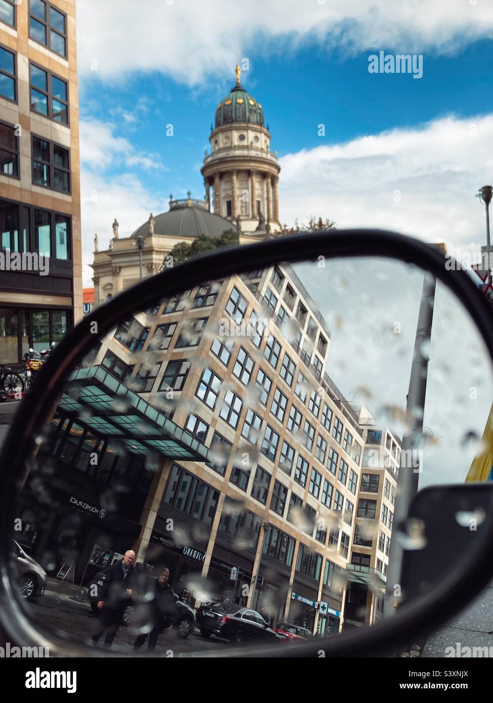 The Neue Kirche (Deutscher Dom) and the Quartier 205 Stadtmitte reflected in the mirror of a Scooter - Smartphone Captured Stock Image