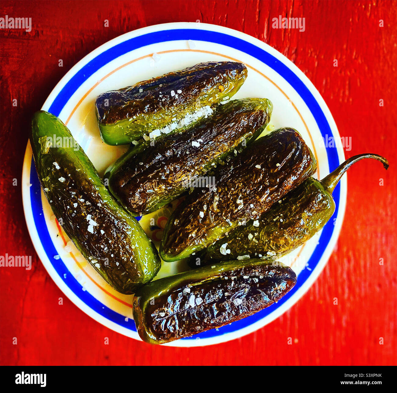 Grilled spicy green cuaresmeño chillis in a plate in Mexico - Smartphone Captured Stock Image