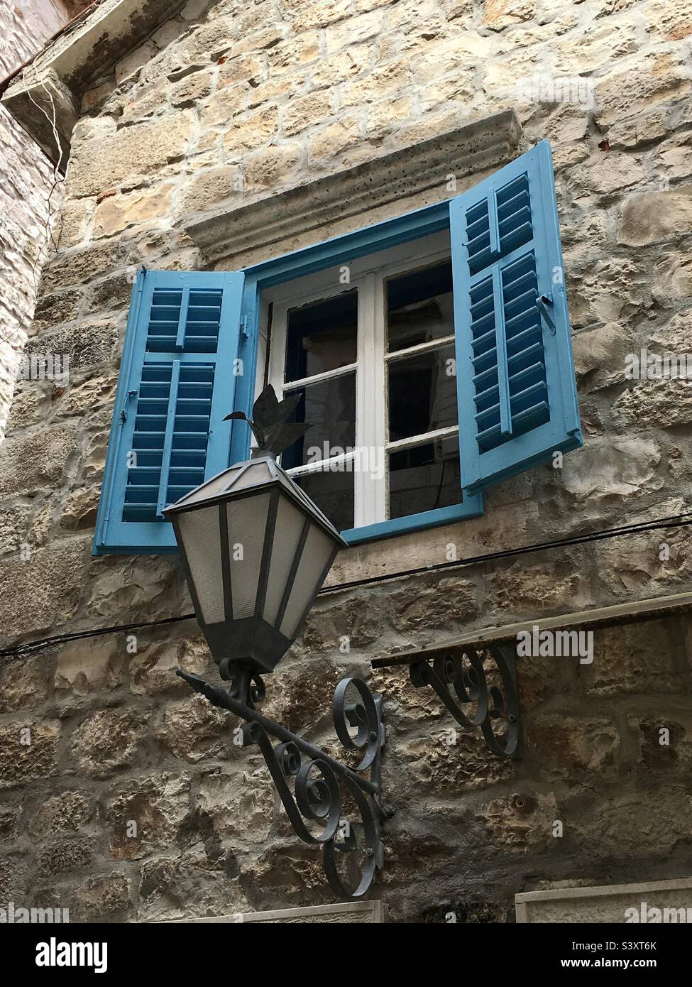 Blue shuttered window with street lamp, Trogir, Croatia. Stock Photo