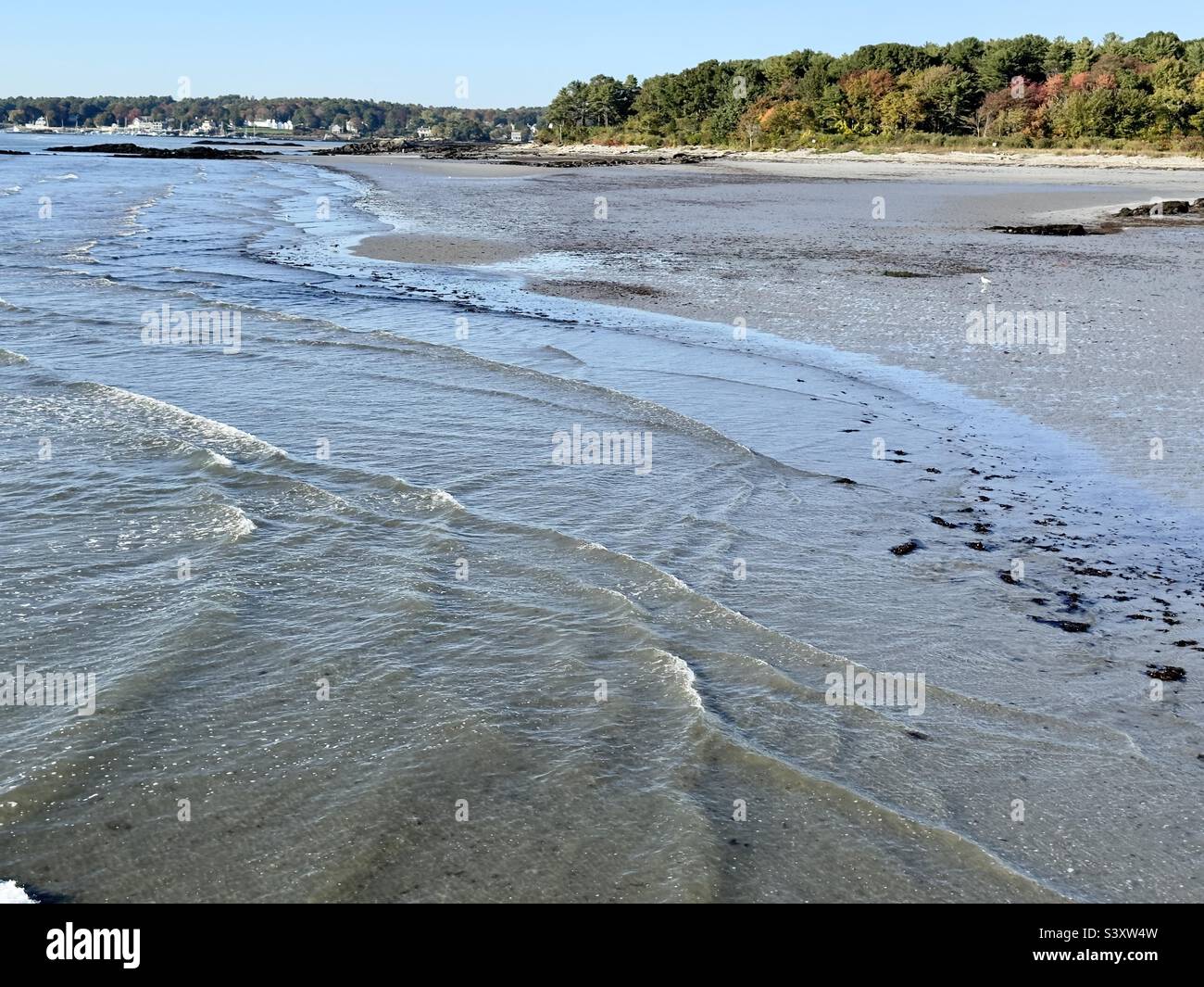 Shallow waves from the incoming tide at the beach in the autumn - Smartphone Captured Stock Image