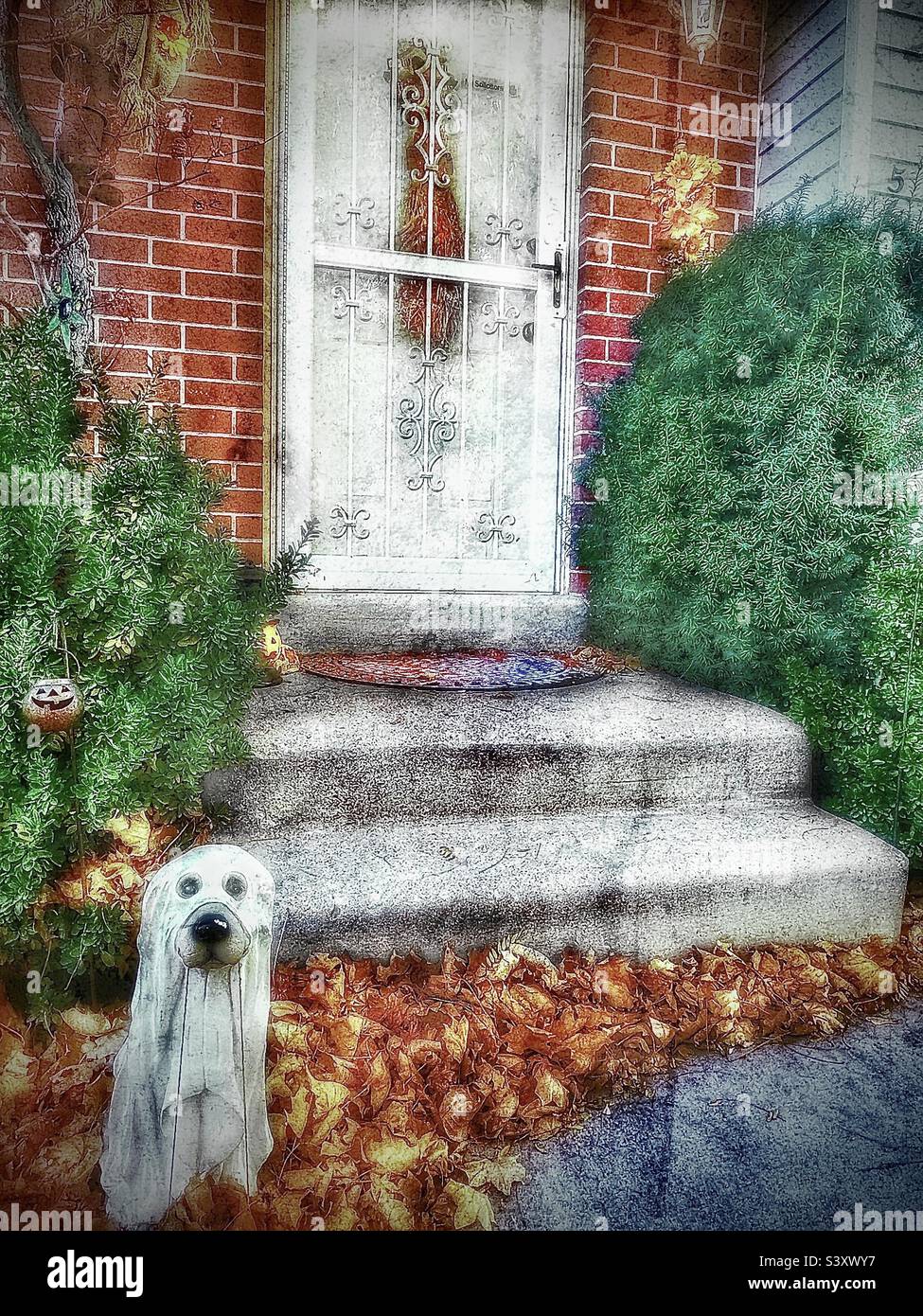 A friendly ghost pup wants to trick or treat too. He stands at the front porch of a Utah, USA home as part of their yard decor each year during October and the Halloween season. - Smartphone Captured Stock Image