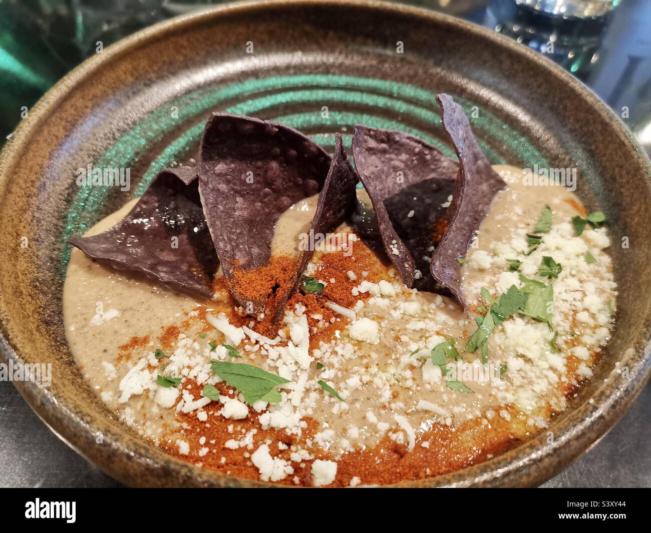 Black bean dip with purple corn chips. - Smartphone Captured Stock Image