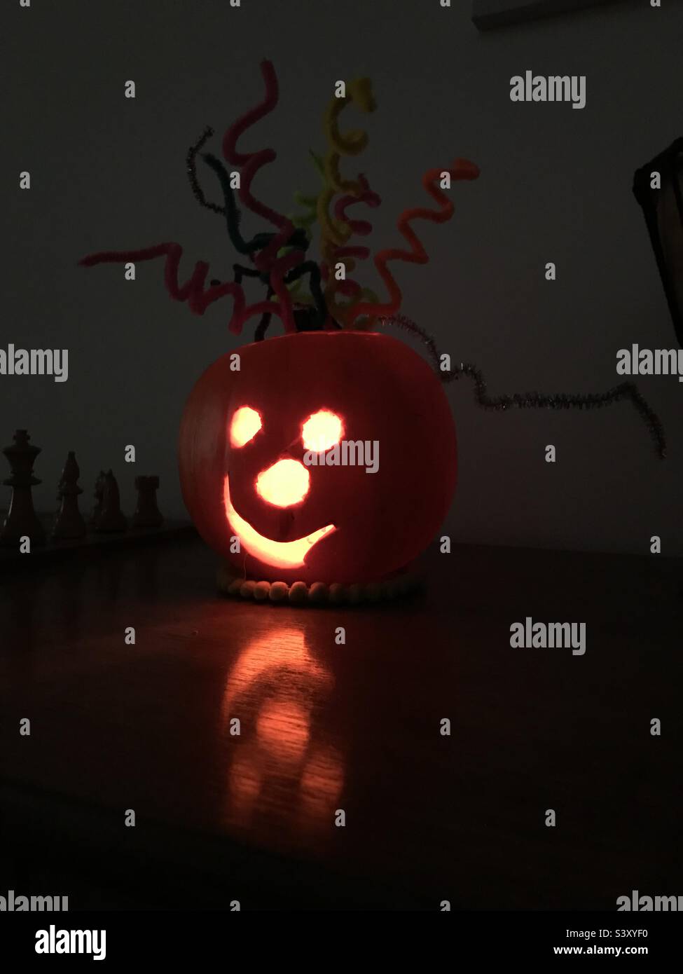 Halloween pumpkin mask with a lit nightlight inside and pipe cleaner