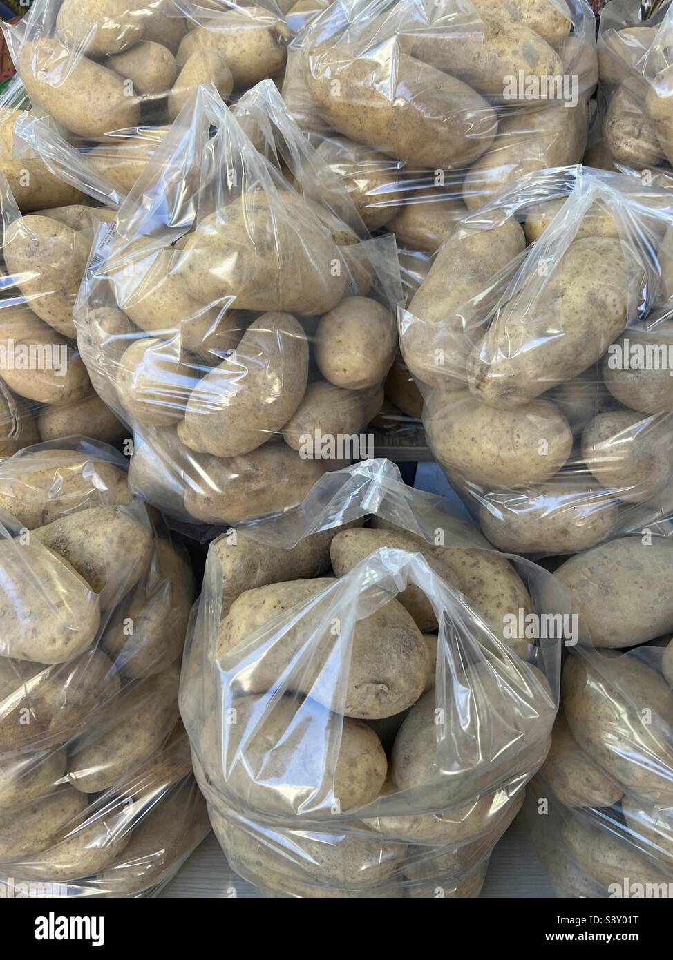 Potatoes in plastic bag stocked for sale. Essential ingredient for