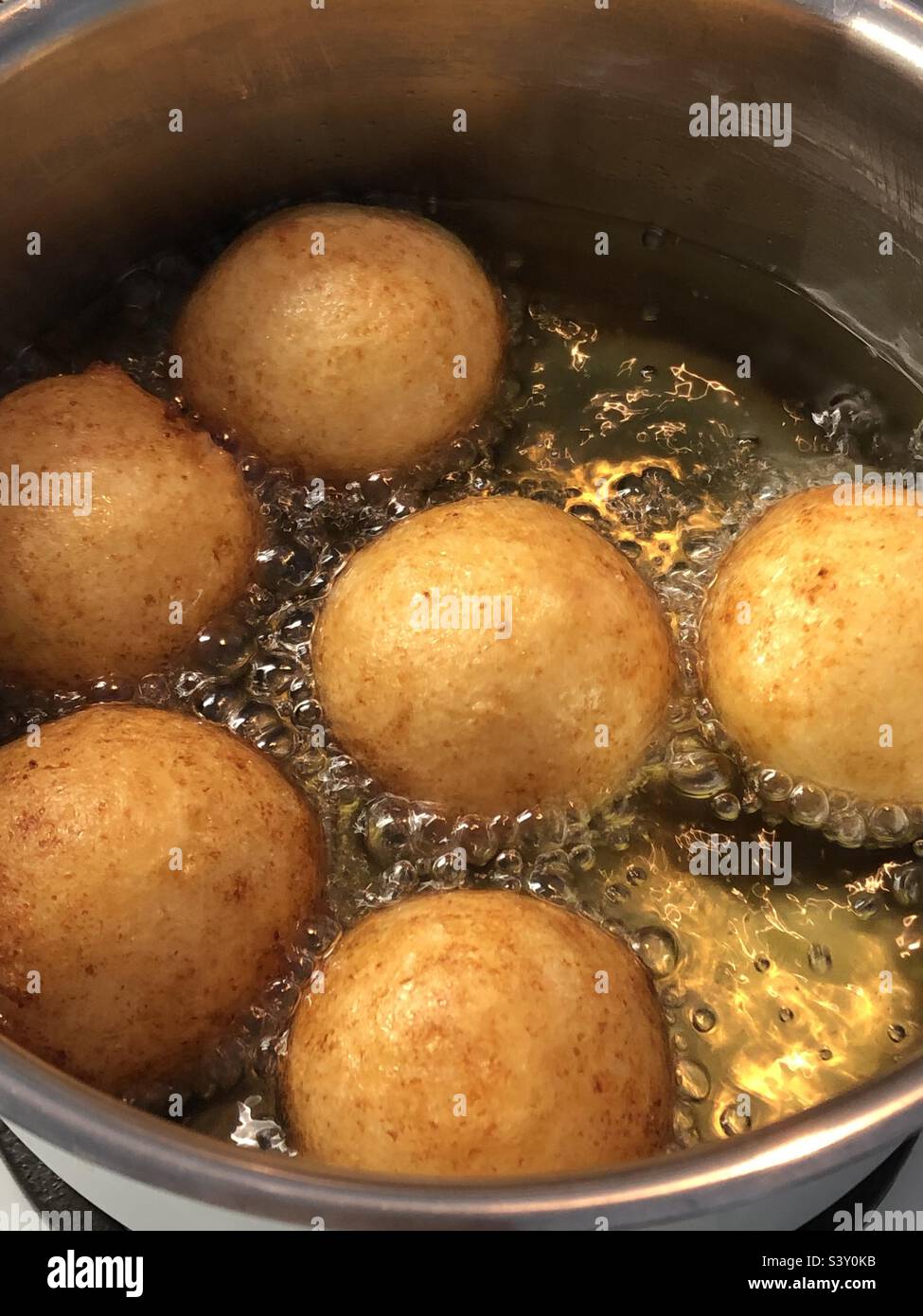 large donuts cooked in oil Stock Photo Alamy