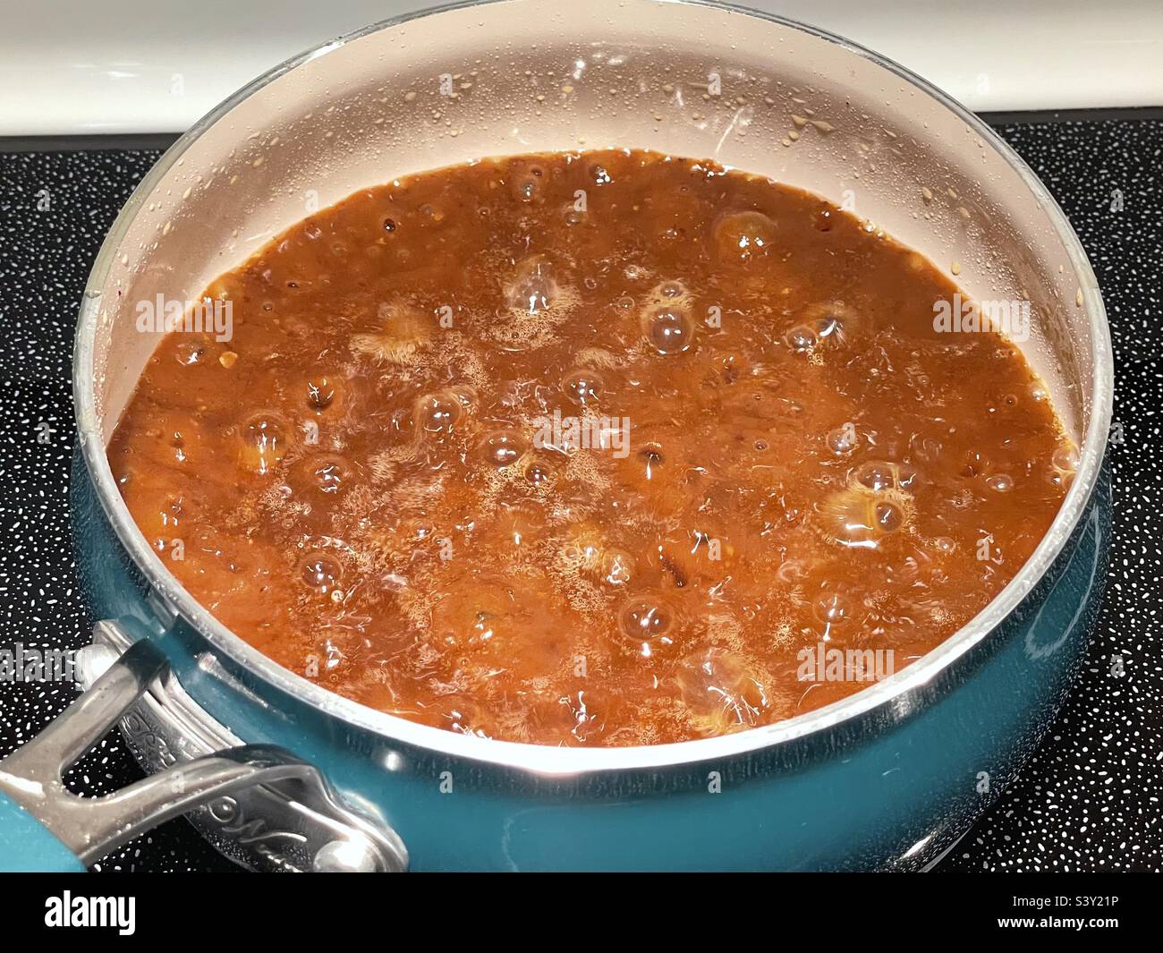 Home made brown gravy, the best around as far as our family goes, simmering on the stove on Thanksgiving Day in Utah, USA. Stock Photo