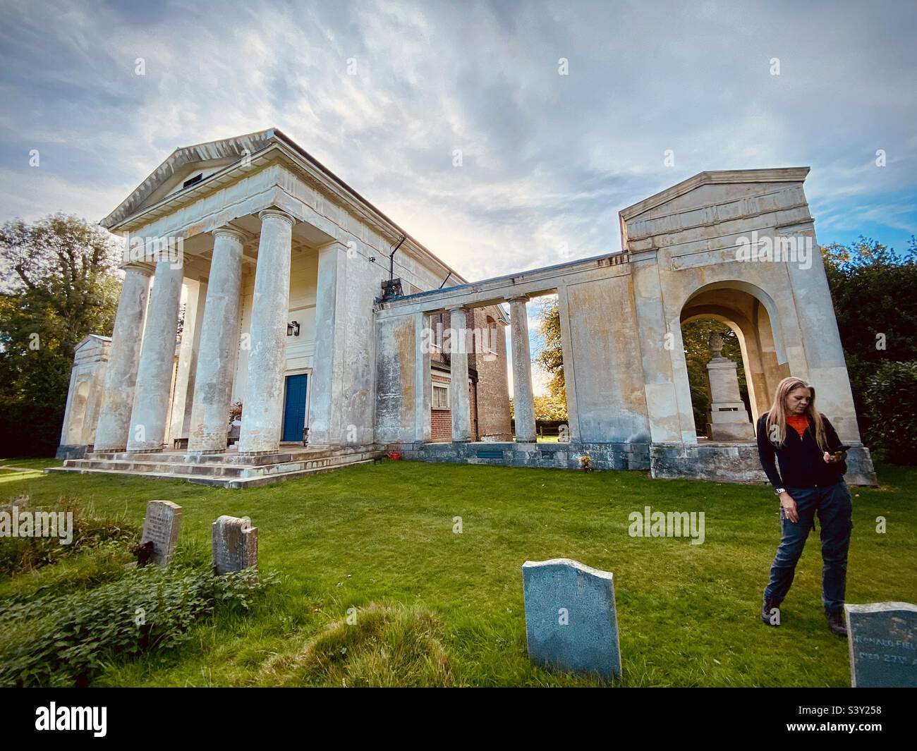 A woman stands near St Lawrence Church in Ayot st Lawrence in Hertfordshire uk - Smartphone Captured Stock Image