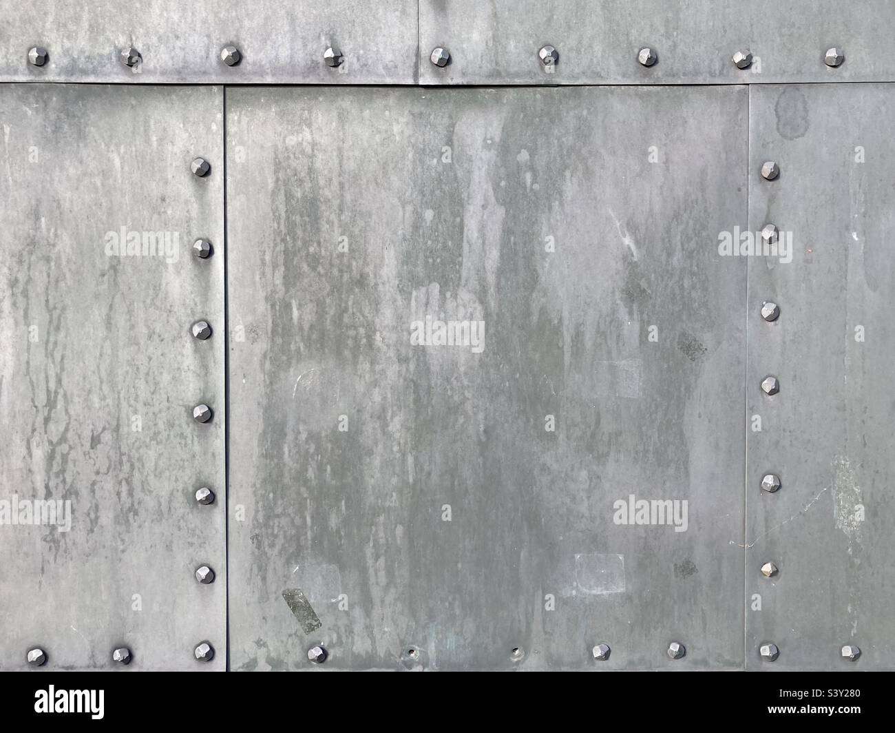 gray metal plates fastened together with rows of rivets - Smartphone Captured Stock Image