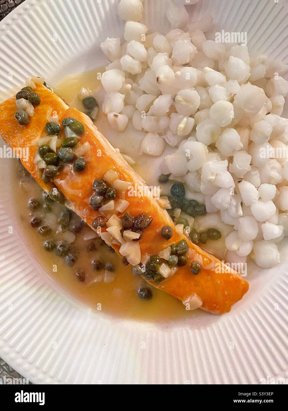 Close up of a gourmet meal of salmon lemon piccata and a side dish of hominy grits, 2022, USA Stock Photo