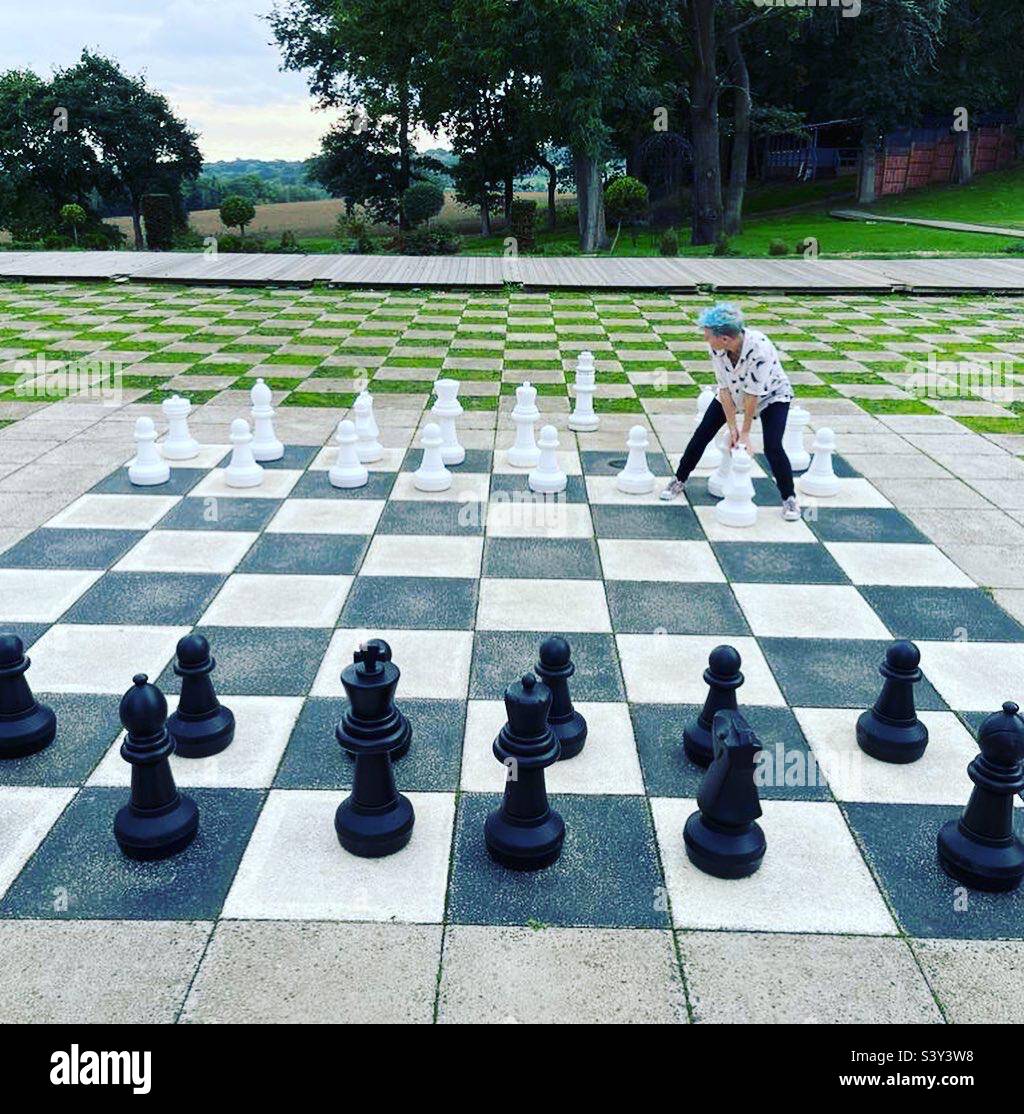 Woman with blue hair playing giant chess - Smartphone Captured Stock Image
