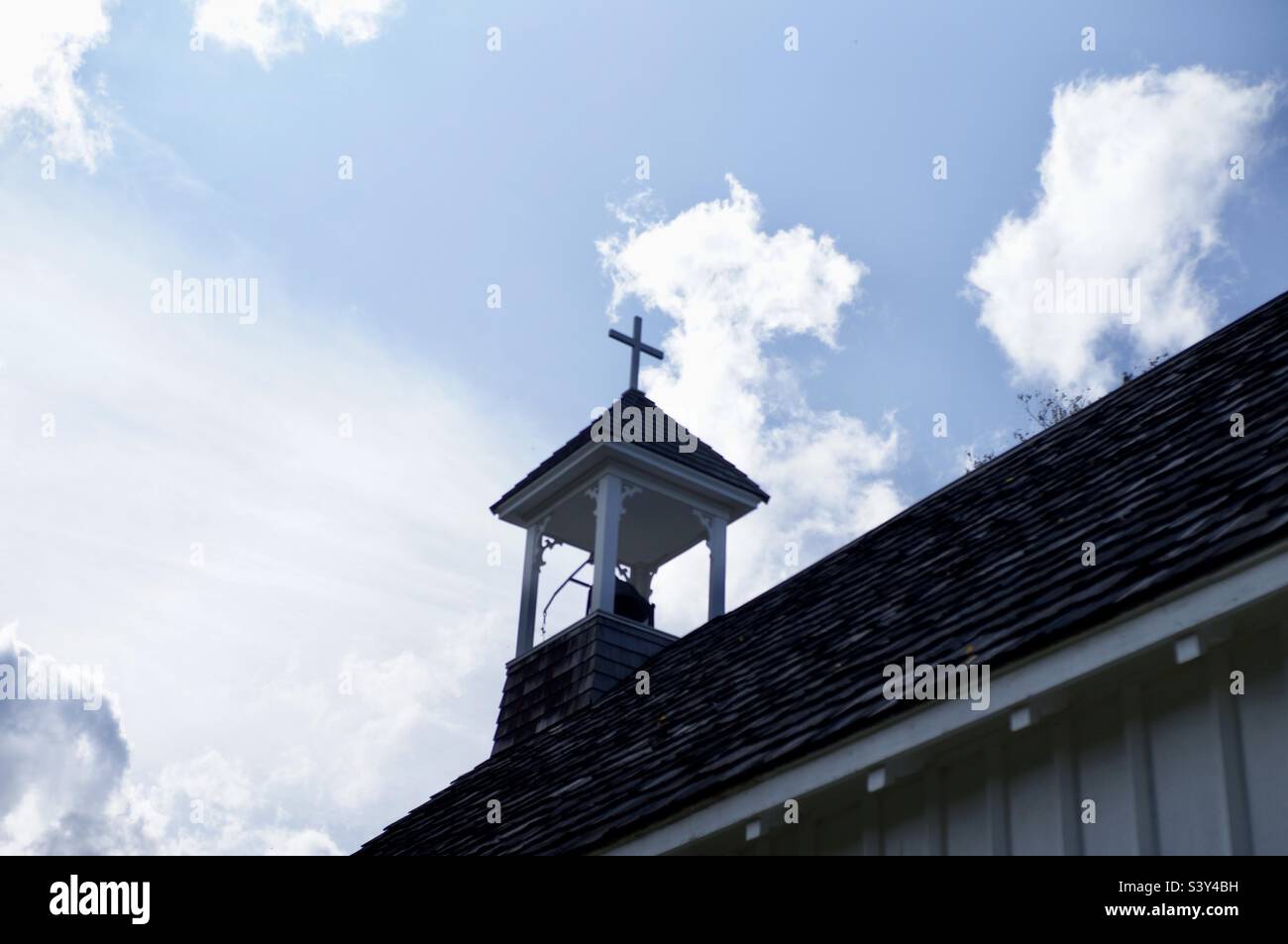 Church steeple against a blue sky with white clouds. - Smartphone Captured Stock Image