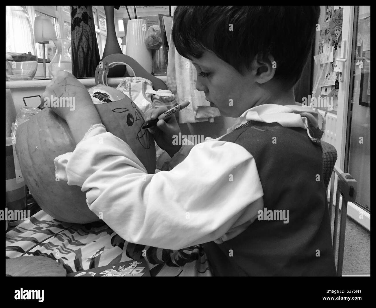 Boy Designing a pumpkin black and white mono Stock Photo